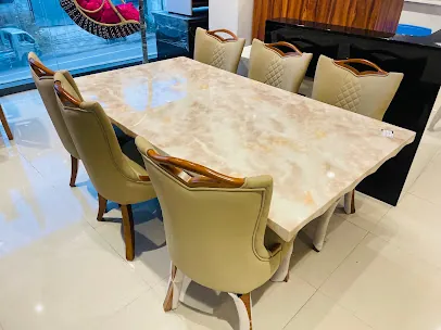 Elegant marble-and-onyx-top dining table with eight cream-upholstered chairs with gold-tone wooden legs, on polished showroom floor